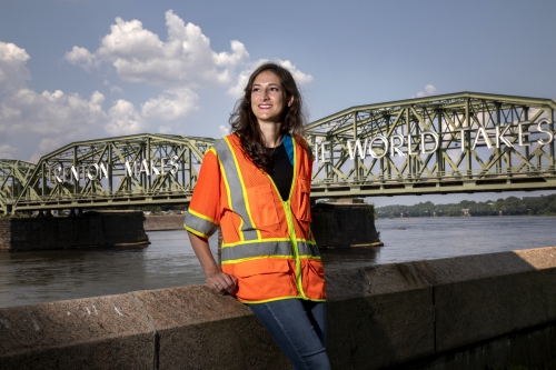 Remy Donahey '14 with an orange vest in front of the Trenton bridge